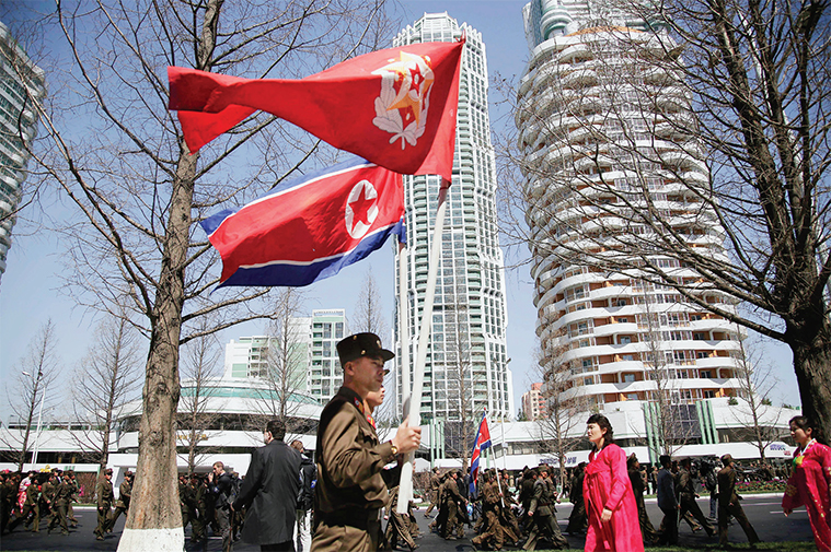  여명거리 준공식이 열린 4월 13일 북한군이 		인공기를 들고 여명거리를 지나고 있다.