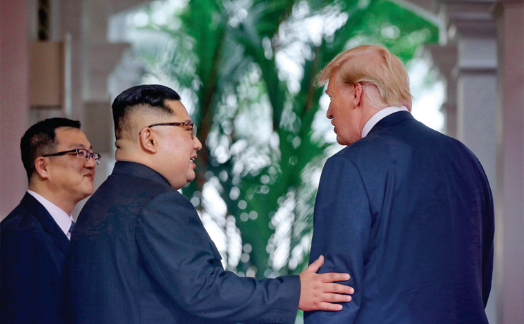김정은 위원장이 6월 12일 싱가포르 북·미 정상회담에서 처음 대면한 트럼프 대통령의 왼팔을 잡고 친근감을 표시하고 있다.