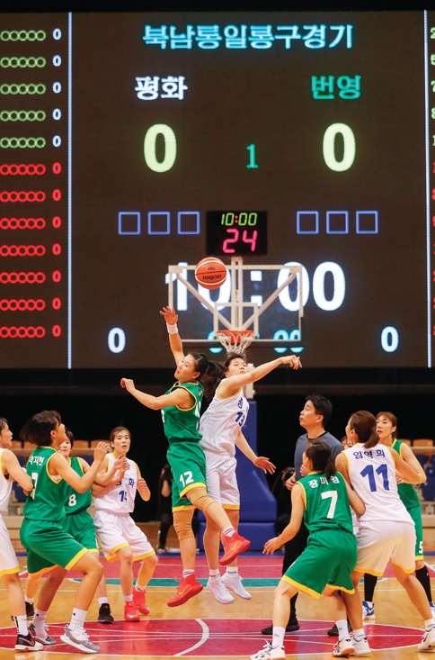 7월 4일 평양 류경정주영체육관에서 개최된 남북 통일농구경기에서 여자 평화팀과 번영팀이 혼합 경기에서 점프볼을 하고 있다.