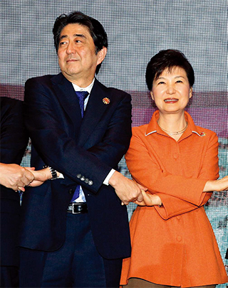 2015년 11월 21일 말레이시아 쿠알라룸푸르 컨벤션센터에서 열린 아세안(ASEAN)+3(한·중·일) 정상회의에서 손을 맞잡은 박근혜 대통령과 아베 일본 총리.